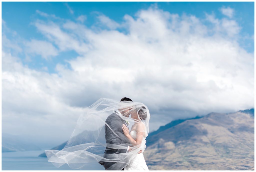 mountaintop queenstown new zealand wind veil bride groom wedding portrait 