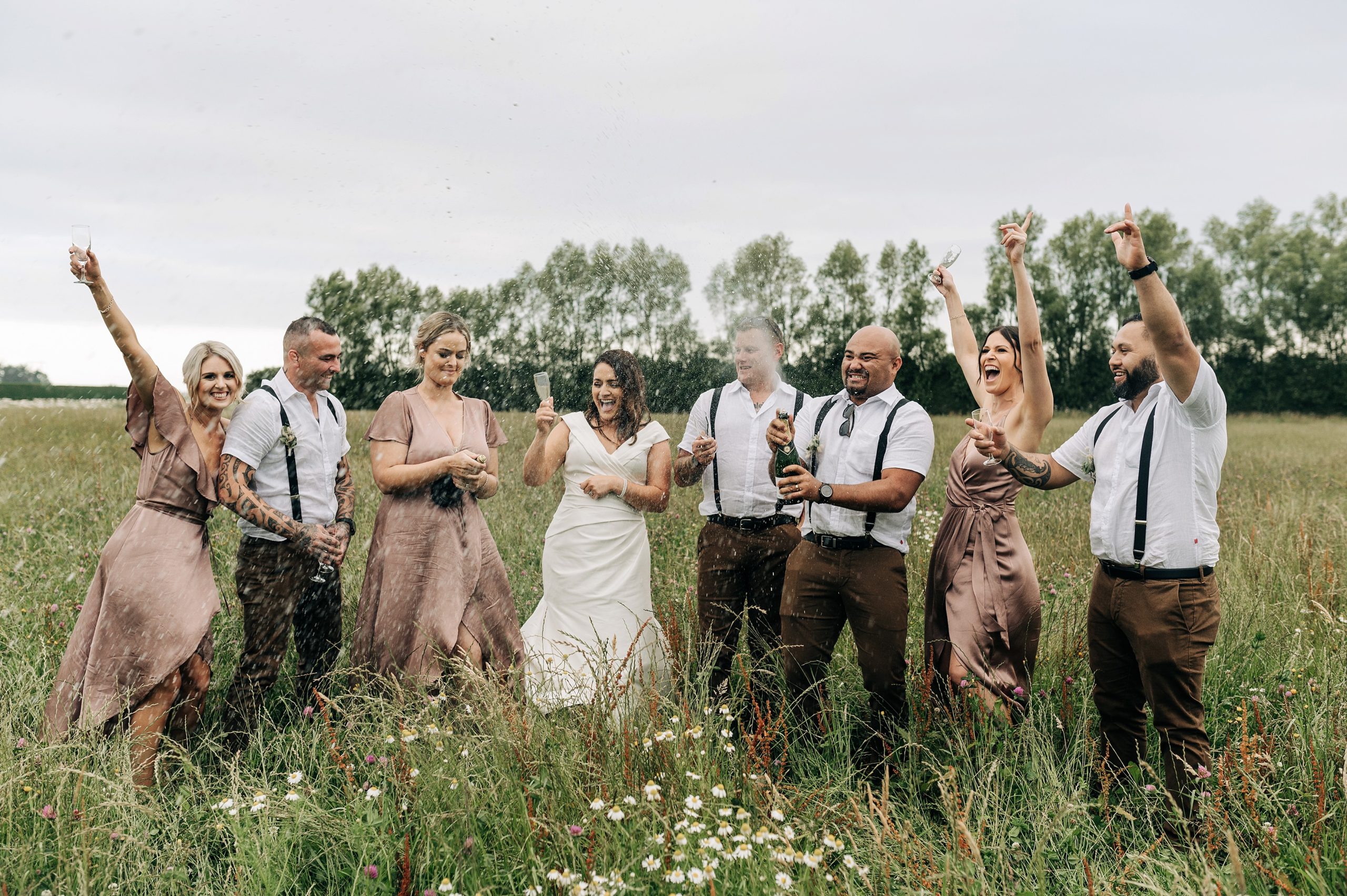 champagne wedding party bridesmaids groomsmen spray laughter christchurch sunset happy cheer candid party celebrate
