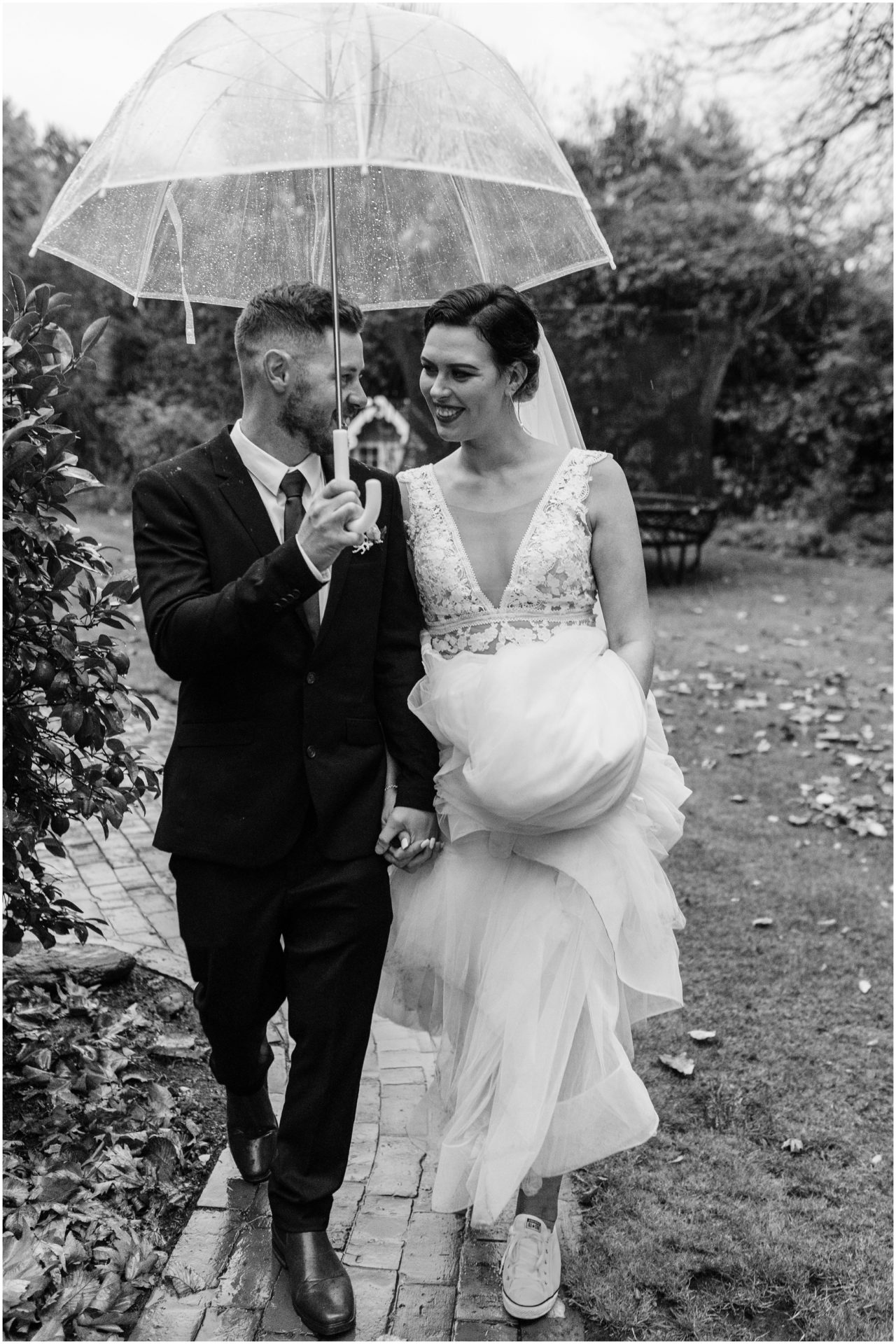 bride groom black white rain winter umbrella cold omarino christchurch wedding photographer walking together 