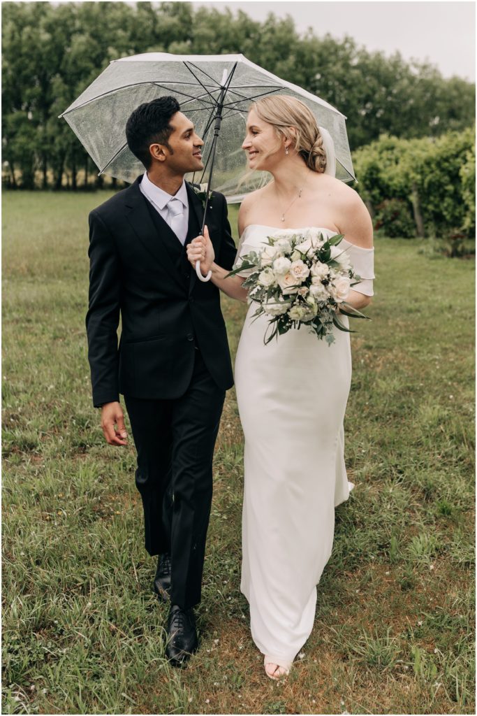 bride groom kissing white dress black suit vineyard trents christchurch wedding photographer green vines cloudy day summer