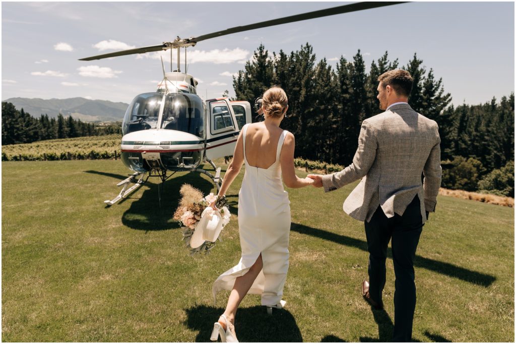 bride groom walk to helicopter lawn summer day bouquet dog point vineyard blenheim