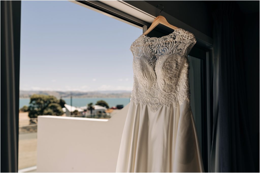 wedding dress hanging in door napier new zealand sea view