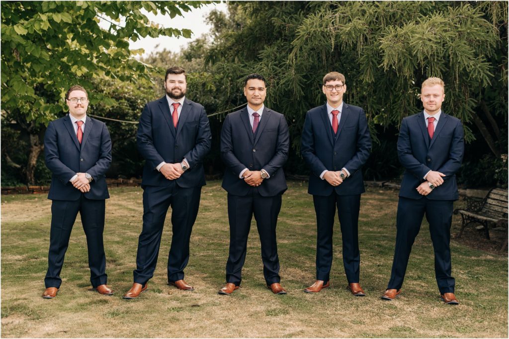 groom and groomsmen in home garden navy blue suits maroon ties brown shoes invercargill wedding new zealand
