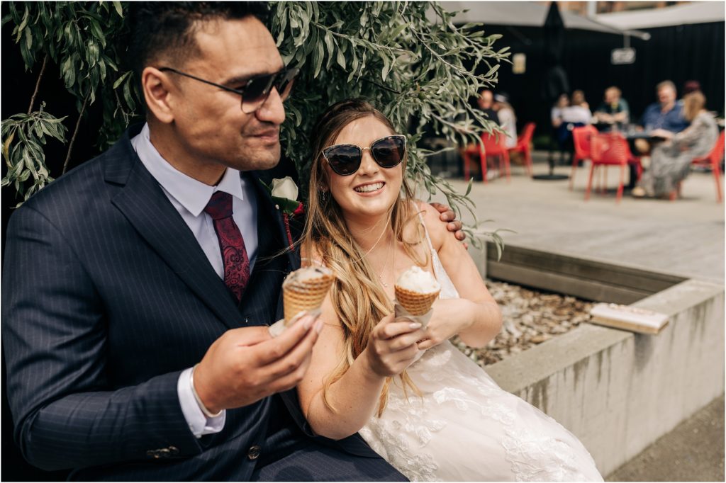 bride and groom eating ice cream at patagonia toasted invercargill on wedding day with sungalsses