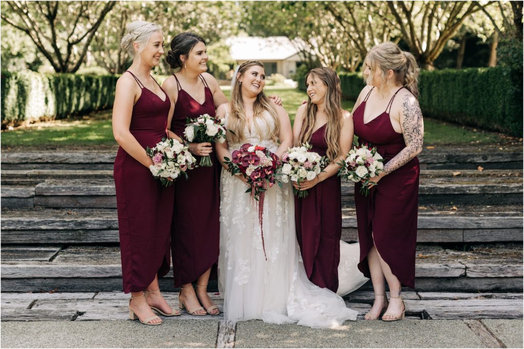 bride and bridesmaids in maroon dresses with bouquets matching styles garden steps hideaway 201 winton invercargill wedding