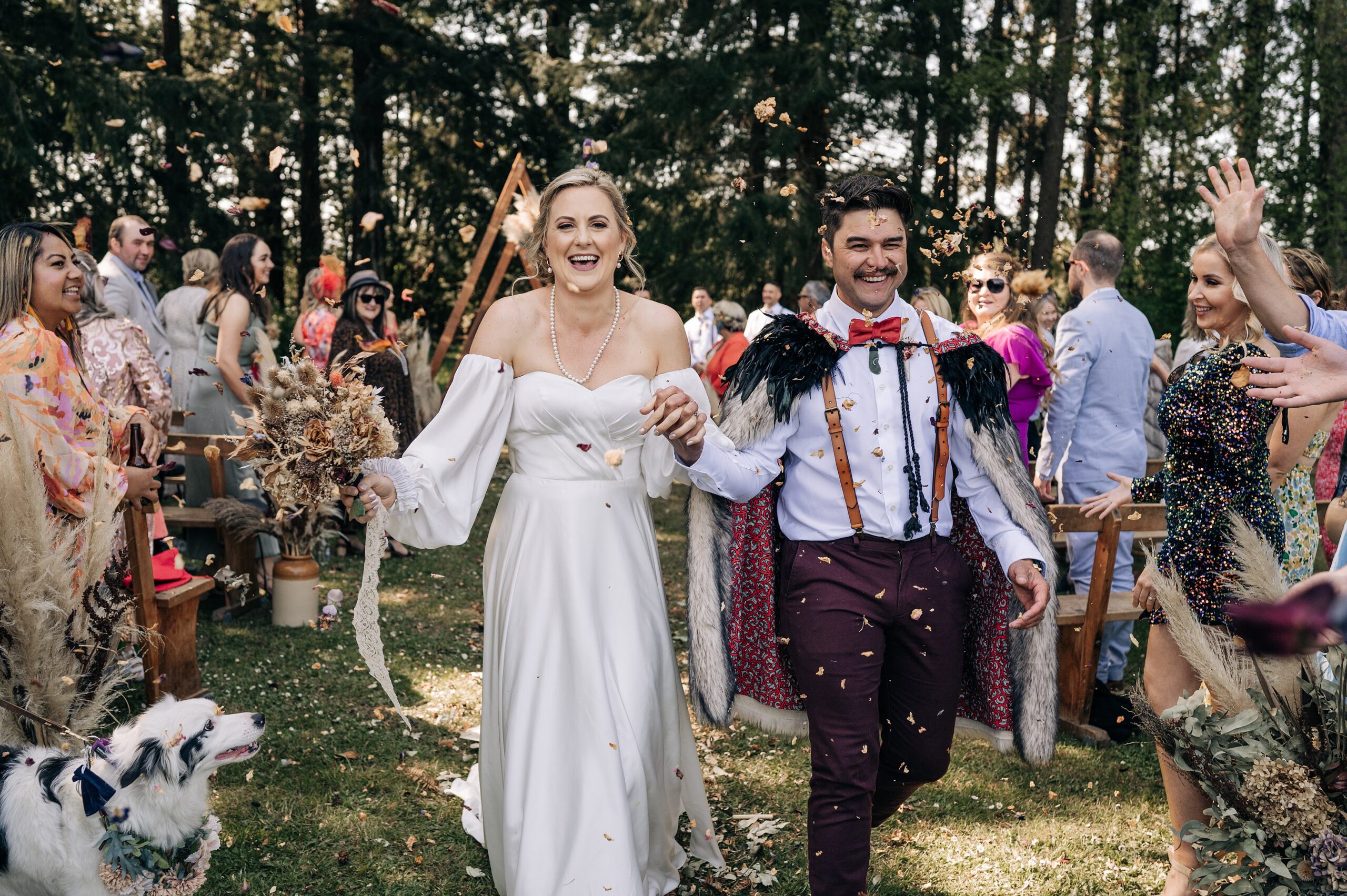 bride and groom walking down aisle with natural confetti being thrown in forest christchurch wedding