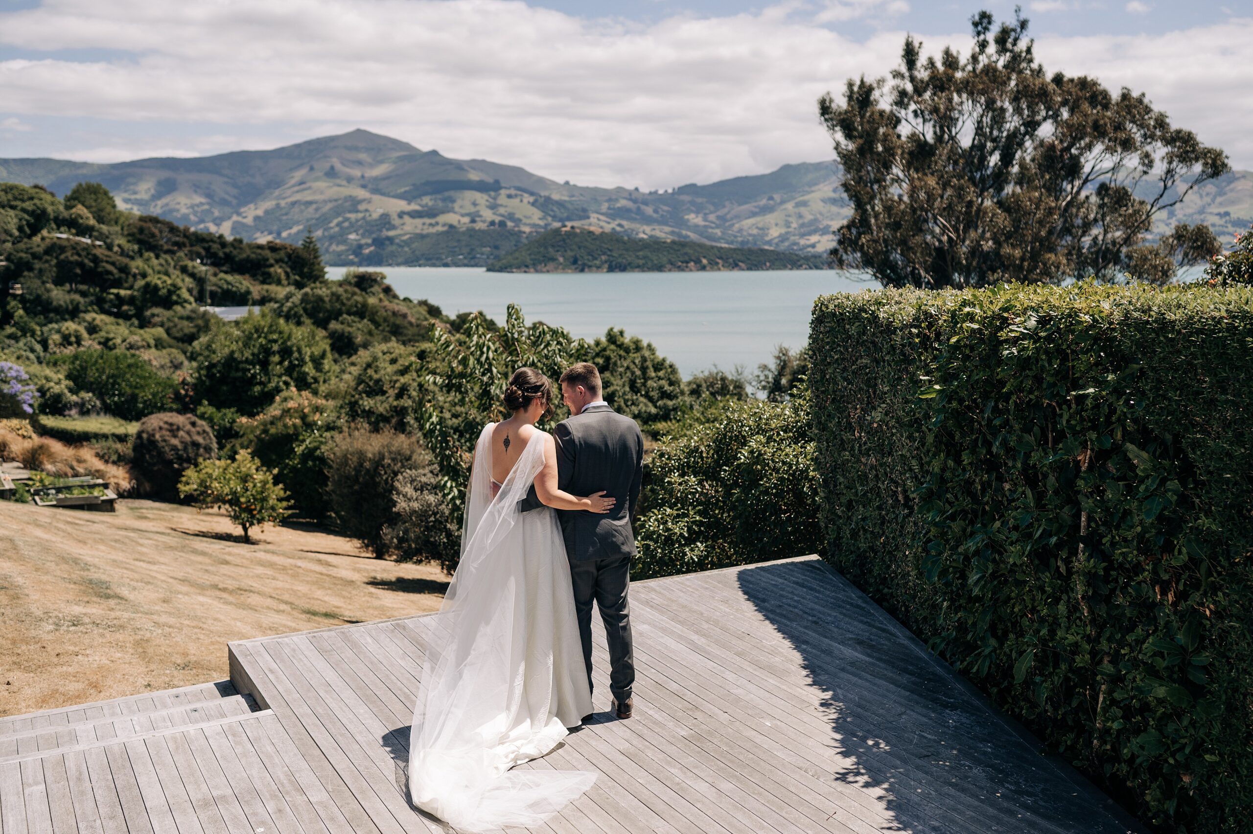 a bride and groom on their wedding day at an airbnb overlooking akaroa harbour