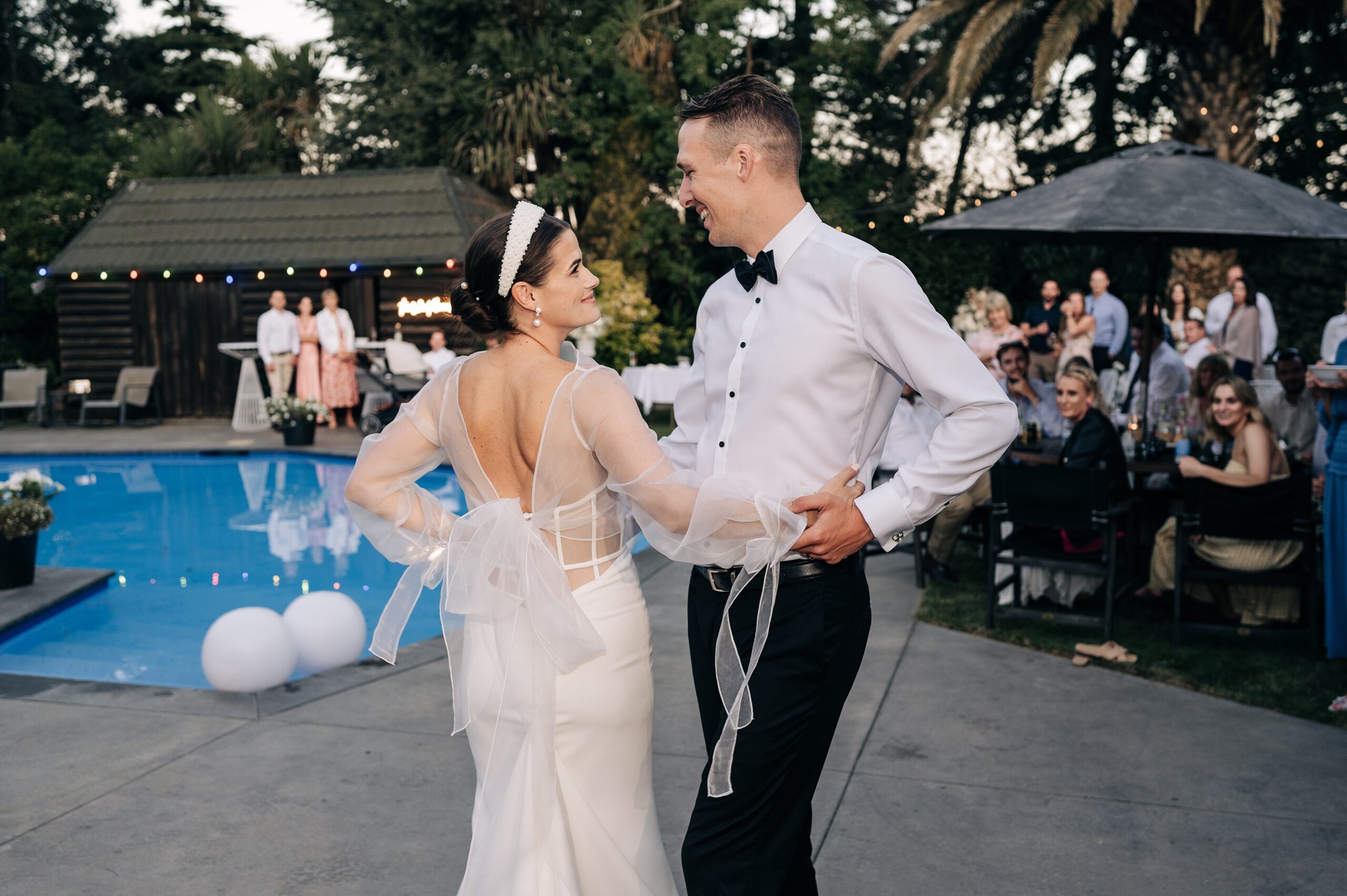 trish peng bride dancing beside a pool with groom in white shirt and black bowtie