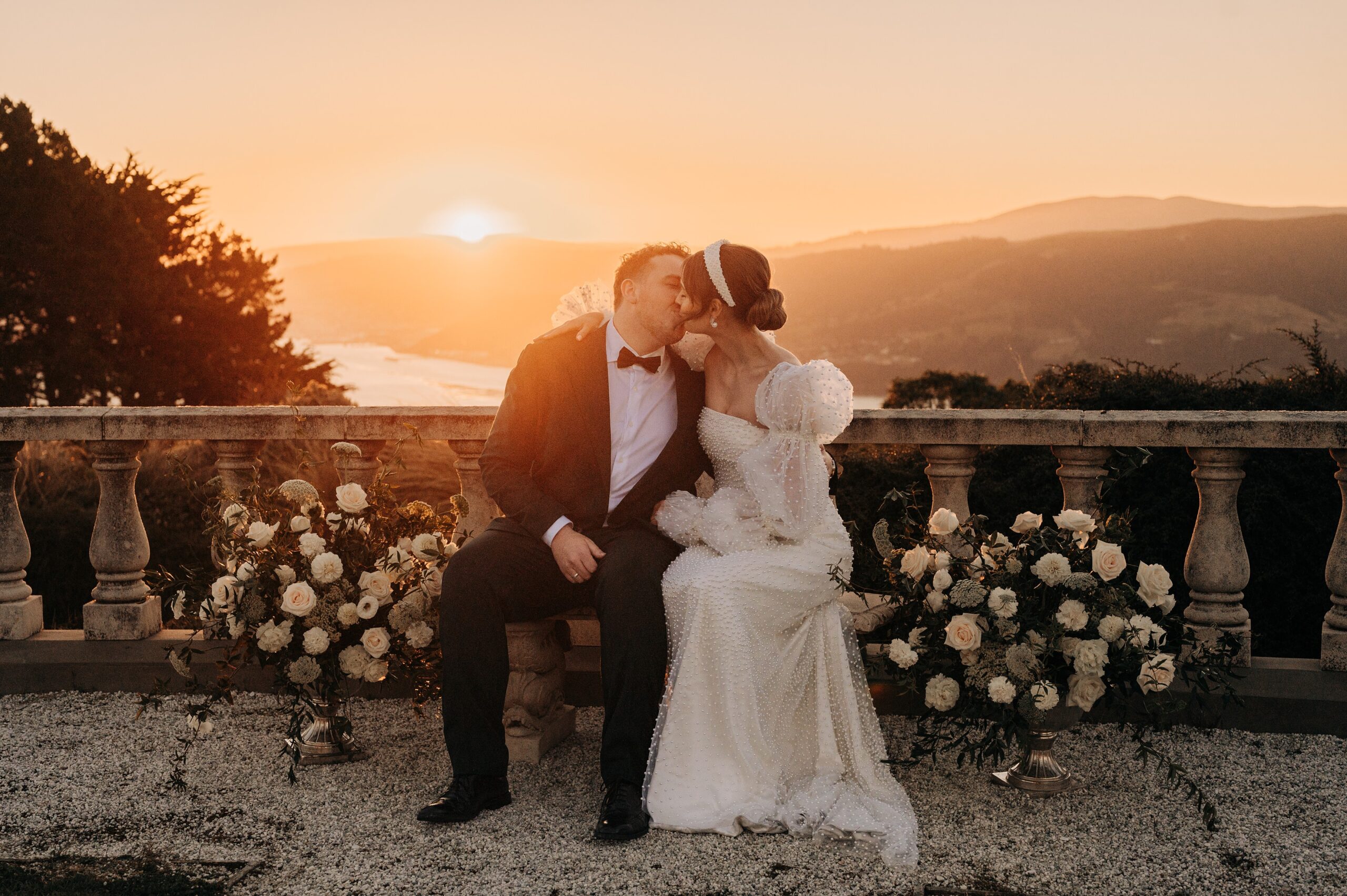 bride and groom in the sunset at larnach castle camp estate overlooking dunedin harbour on their wedding day