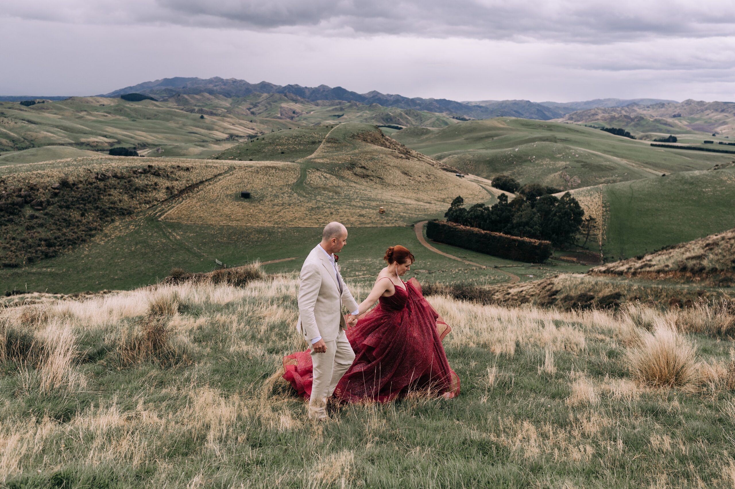 bride and groom walk across mountaintop in their new zealand elopement